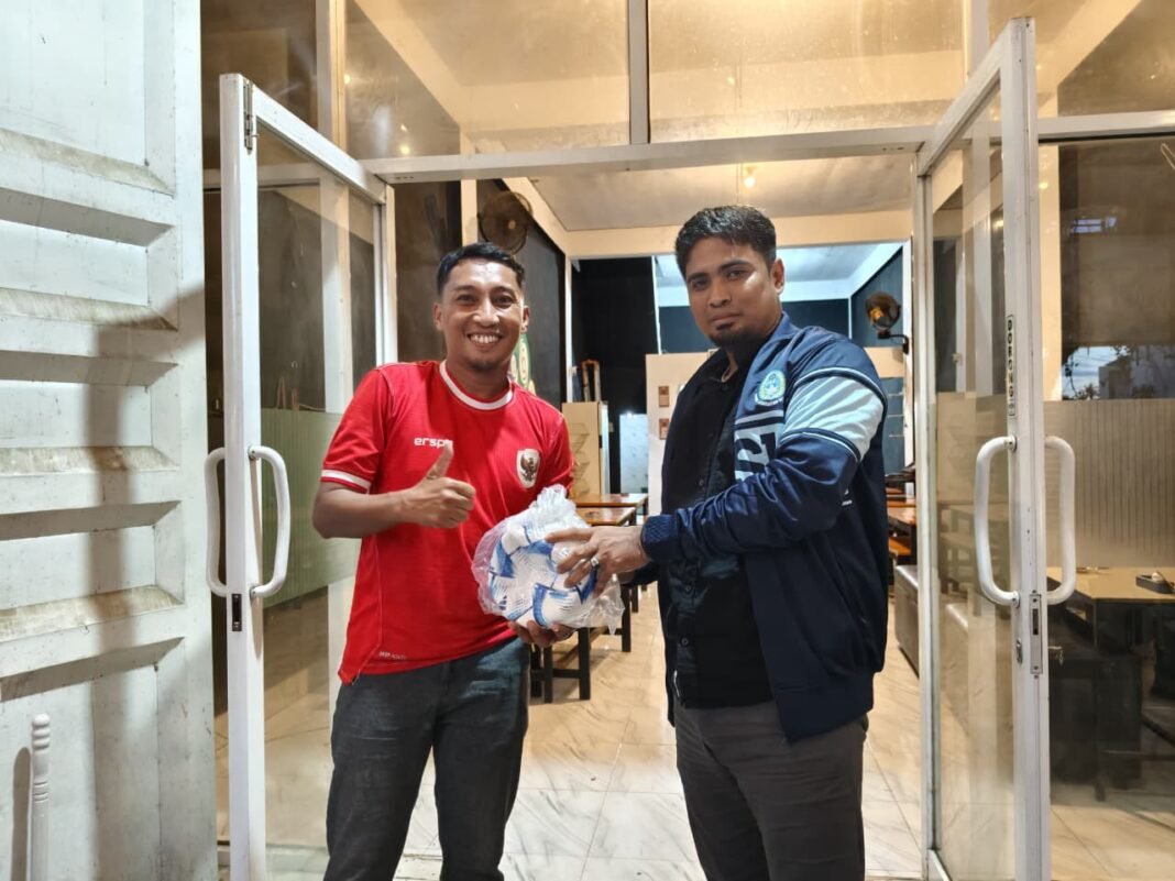 Perwakilan PSSI Sulbar, Herman Kadir saat menyerahkan bola untuk anak SD di Wonomulyo. (Foto: Opsi/Eka)