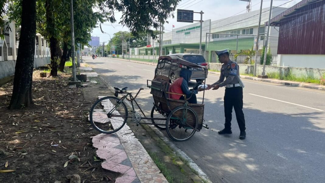 Personel Ditlantas Polda Sulbar, saat memberikan nasi kotak ke tukang becak. (Foto: Opsi/Eka)