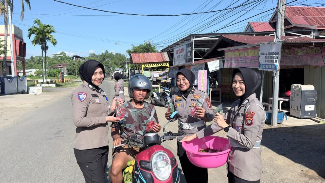 Personel Ditlantas Polda Sulbar saat membagikan hasil panen kebun ke pengendara