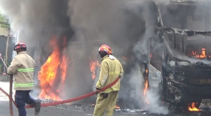 Bus Eka Terbakar 3 Km Jelang Terminal Purbaya, Satu Penumpang Terluka Petugas Damkar memadamkan api yang membakar bus di Madiun. (Foto: Video viral)