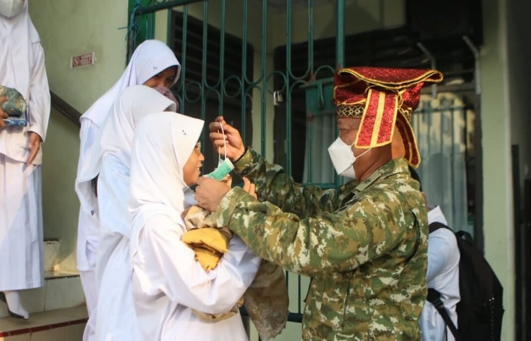 TNI saat membagikan masker kepada anak sekolah